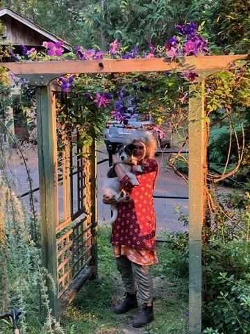 woman in red dress with small dog and purple flowers